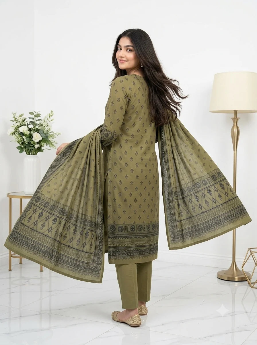 Woman wearing a green traditional outfit with a matching dupatta in a minimalistic room.