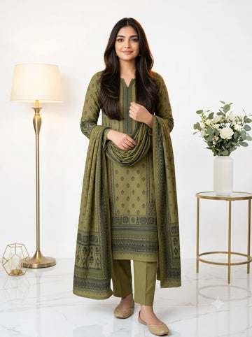 Woman wearing a green traditional outfit with a matching dupatta in a well-lit room.