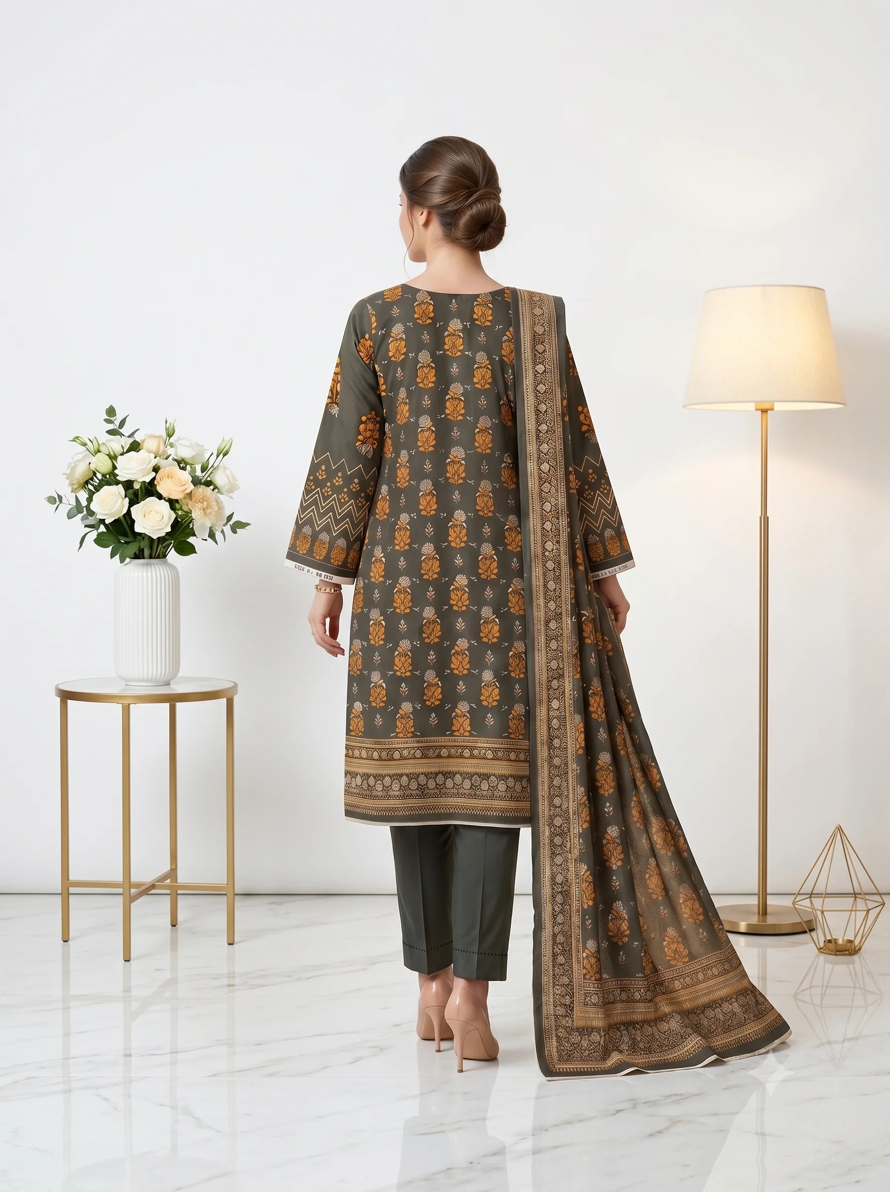 Woman wearing a traditional outfit with a patterned shawl in a minimalistic room.