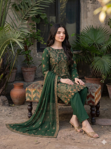 Woman in a green traditional outfit sitting on a patterned stool with plants in the background
