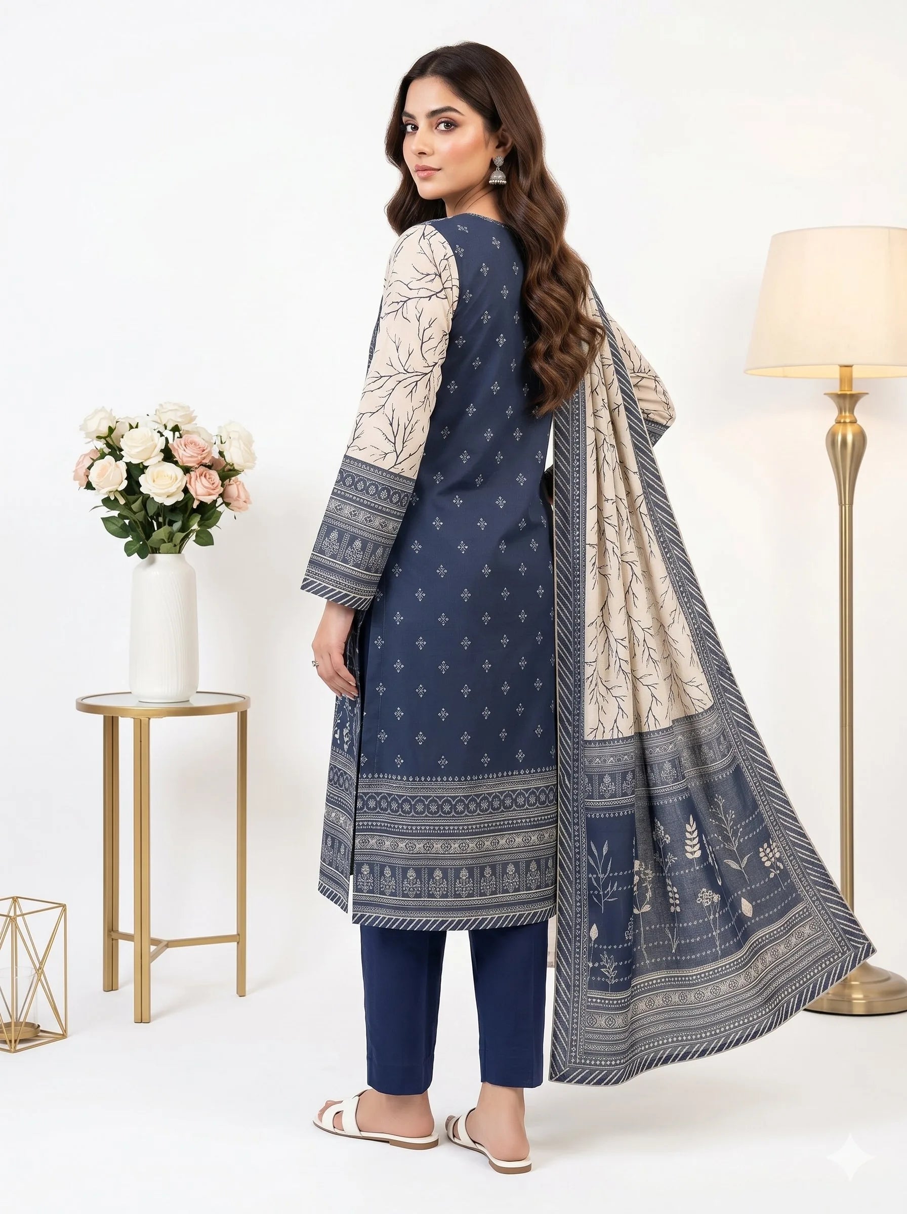 Woman wearing a blue and white traditional outfit with a matching dupatta, standing in a well-lit room.
