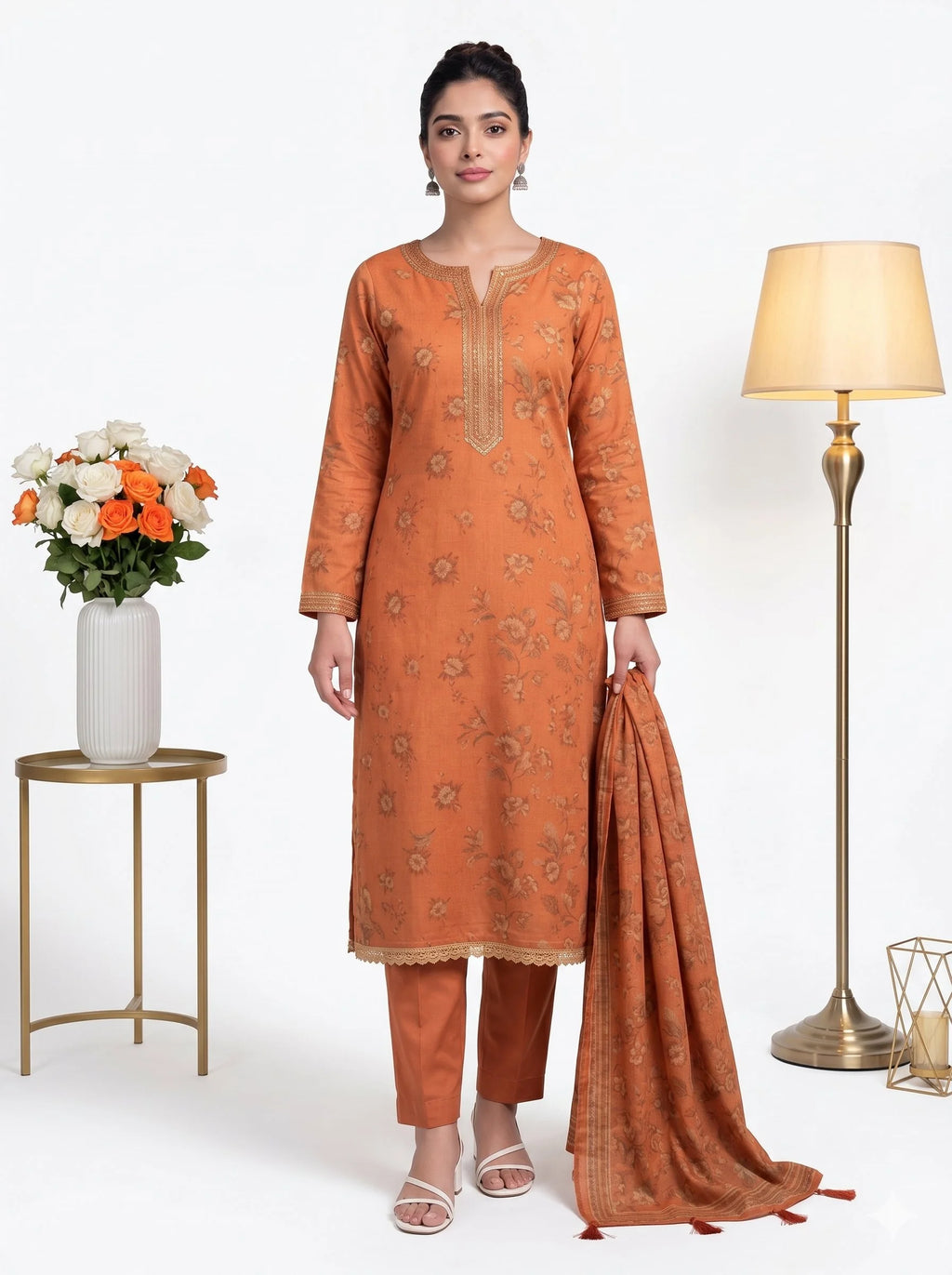 Woman wearing an orange traditional outfit with a lamp and flowers in the background