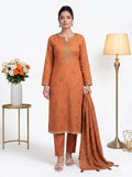 Woman wearing an orange traditional outfit with a lamp and flowers in the background