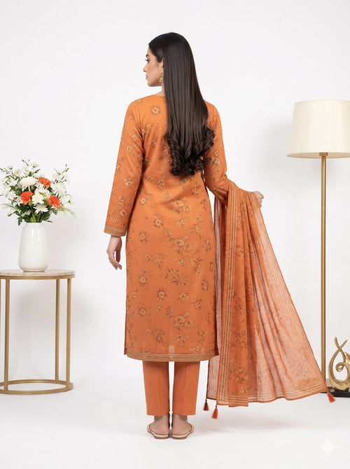 Woman wearing an orange traditional outfit with a matching dupatta in a minimalistic setting.