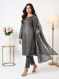 Woman wearing a gray traditional outfit with a matching dupatta in a minimalistic setting.