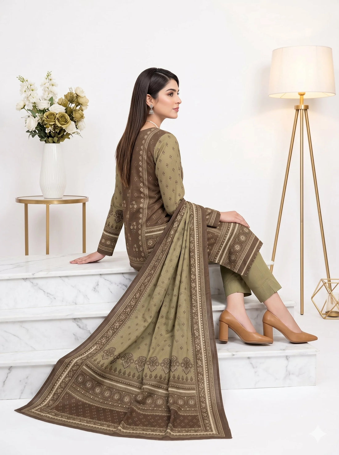Woman wearing a brown and green traditional outfit with a matching dupatta, standing against a white background.