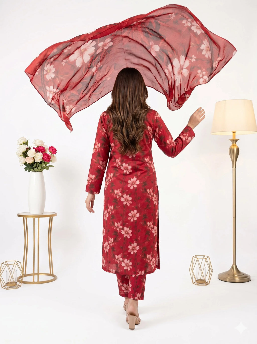 Woman in a red floral dress holding a matching scarf with a white background