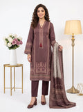 Woman in a patterned outfit holding a dupatta with a vase and lamp in the background