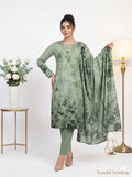 Woman wearing a green floral dress with a matching dupatta, standing against a white background.