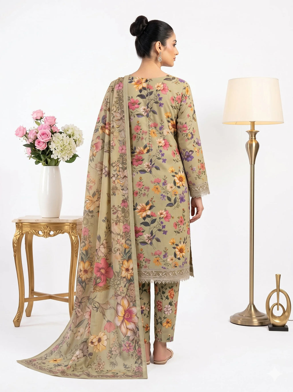 Woman wearing a floral dress with a matching dupatta in a home setting.