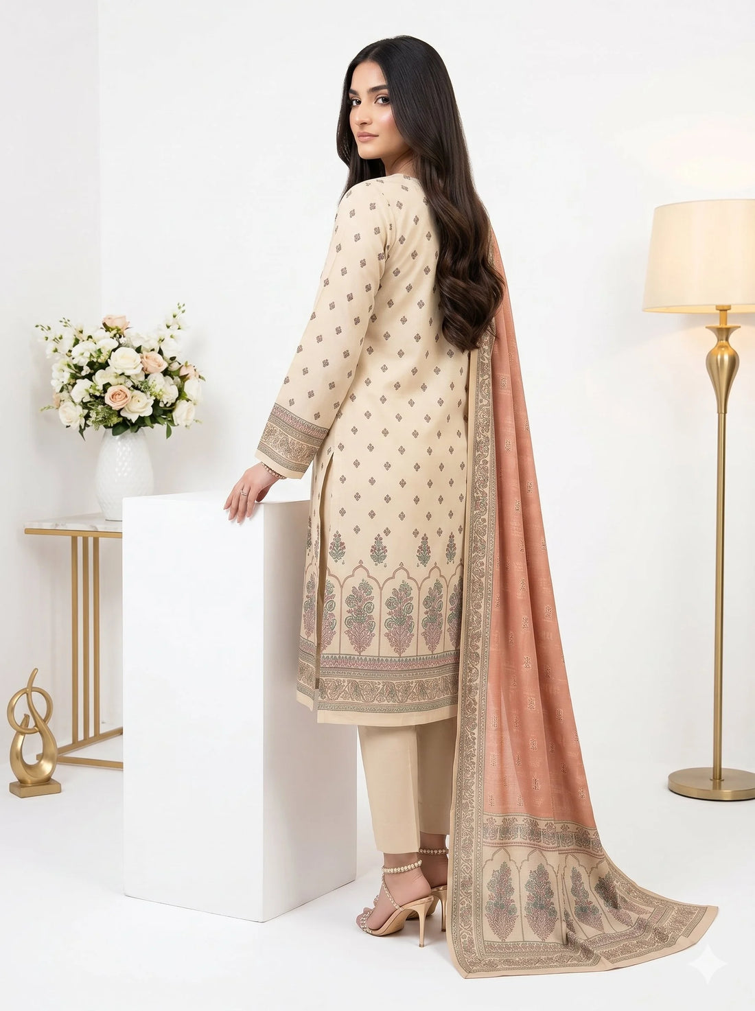 Woman wearing a traditional outfit with a pink dupatta in a well-lit room.